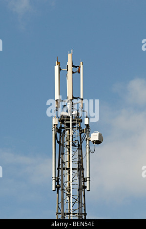 Un mât de téléphonie mobile contre un ciel bleu dans une zone résidentielle Banque D'Images