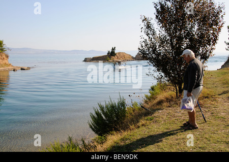 Homme qui regarde un bateau sur l'entrée du canal à Nea Potidaia Potidaia la Grèce du Nord Banque D'Images