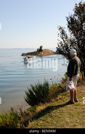 Homme qui regarde un bateau sur l'entrée du canal à Nea Potidaia Potidaia la Grèce du Nord Banque D'Images