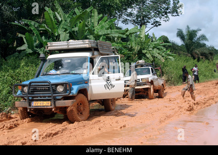 Off-road les véhicules quatre roues motrices coincé dans la boue du chemin de terre boueux durant la saison des pluies, le Gabon, l'Afrique Centrale Banque D'Images