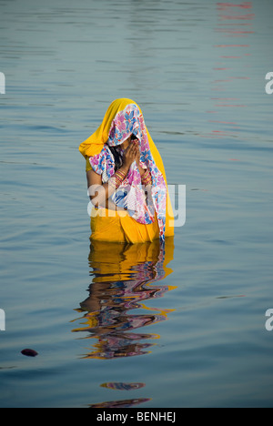 Woman performing Chatth Pooja à rivière Yamuna Ghats New Delhi Inde Banque D'Images