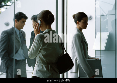 L'arrivée et au départ des cadres par entrée d'immeuble de bureaux Banque D'Images