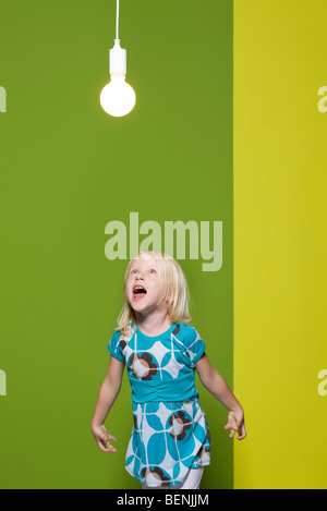 Petite fille en criant à l'ampoule lumineuse Banque D'Images