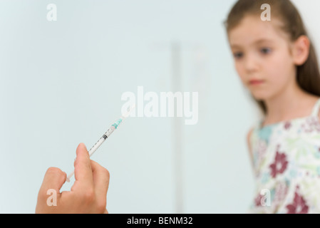 Doctor holding syringe, prépare à vacciner little girl, portrait