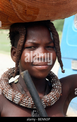 Femme Himba transportant des marchandises sur la tête, Kaokoland / Kaokoveld, région de Kunene, le nord de la Namibie, Afrique du Sud Banque D'Images