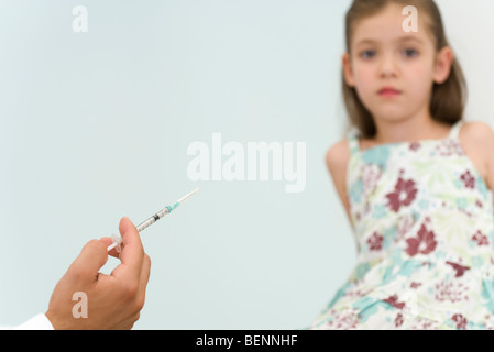 Doctor holding syringe, prépare à vacciner little girl, portrait