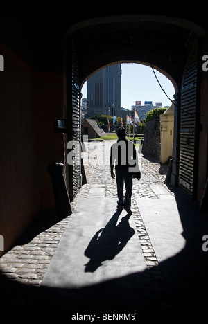 Silhouette d'un homme avec chapeau marche à travers une porte vers la lumière. Cape Town, Afrique du Sud, l'Afrique. Banque D'Images