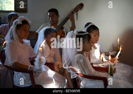 Première communion catholique du Guatemala et de masse aux Remate, El Petén. Les filles et les musiciens lors d'une cérémonie. Banque D'Images