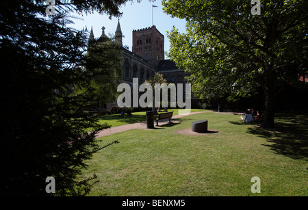La tour principale et obscurci extrémité ouest de St Alban's cathedral,vue d'un jardin calme à l'est de la cathédrale. Banque D'Images