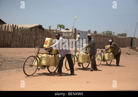 Scène de rue du Soudan du Sud à Juba. Hommes portant des bidons remplis d'eau qu'ils ont recueillis dans le Nil. Banque D'Images