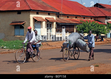 Les cyclistes et le transport des marchandises sur l'homme noir location à Jinja, en Ouganda, l'Afrique Banque D'Images