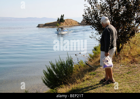 Homme qui regarde un bateau sur l'entrée du canal à Nea Potidaia Potidaia la Grèce du Nord Banque D'Images