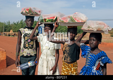 Les enfants noirs portant des fruits sur leurs têtes le long chemin de terre, Sahel, Mali, Afrique de l'Ouest Banque D'Images