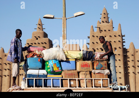 Deux hommes noirs accumulent une assurance en plus de bus en face de la Grande Mosquée de Djenné, Mali, Afrique de l'Ouest Banque D'Images