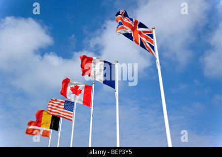 Les drapeaux sur hampes de voler dans le vent contre ciel nuageux Banque D'Images