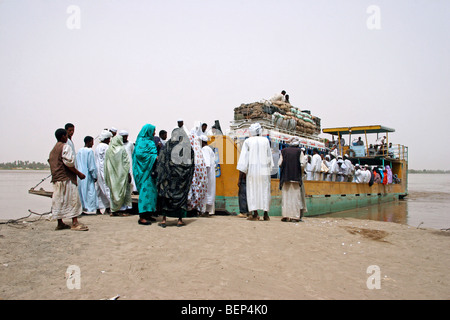 Les passagers nubien vêtu en thawbs / thobes / dishdashas ferry embarquement sur le Nil, au Soudan, en Afrique du Nord Banque D'Images