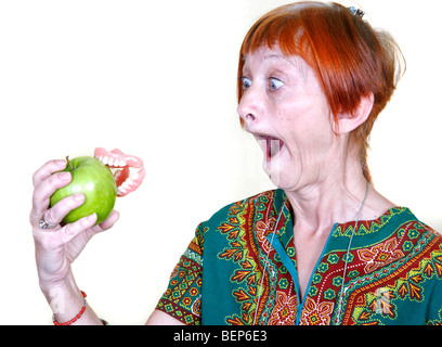 Dame âgée perdre ses dents sur une bouchée d'une pomme Banque D'Images