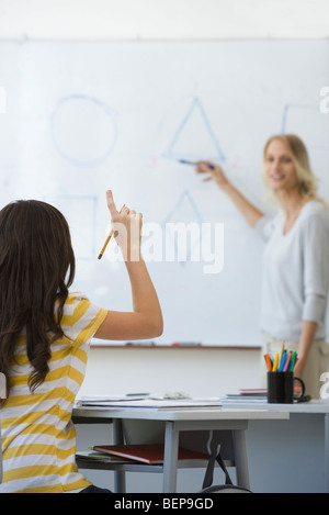 High school student raising hand, répondre aux questions de l'enseignant Banque D'Images