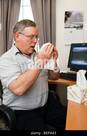 Un homme éternuements Banque D'Images