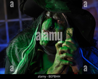 Portrait d'une vieille sorcière effrayante allumé avec éclairage vert bleu étrange Banque D'Images