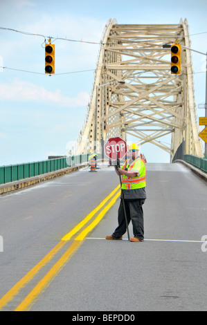 Travailleur de la construction contrôle le trafic du pont international reliant Sault Ste. Marie Michigan USA et Canada de l'Ontario Banque D'Images