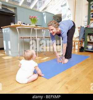 Maman faire du yoga avec un bébé Banque D'Images