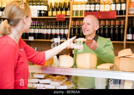 Propriétaire de magasin de fromage avec le client en boutique Banque D'Images