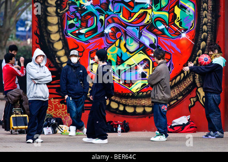 Les jeunes traînant en face de graffitis dans Parc Yoyogi, Tokyo, Japon Banque D'Images