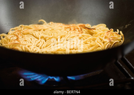Nouilles aux oeufs frits la cuisson à l'anneau de gaz Banque D'Images