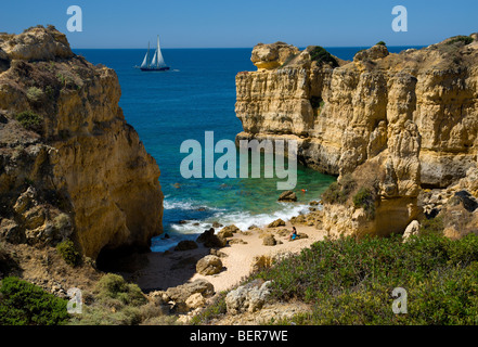 Une petite crique près de, Albufeira, Algarve, Portugal avec un yacht lointain Banque D'Images