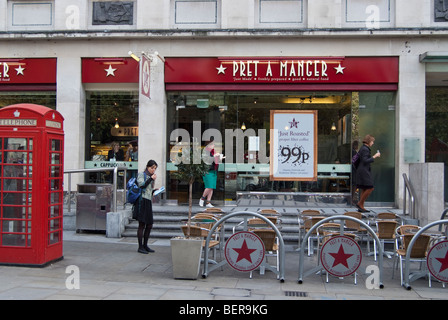 Pret a manger sandwich shop à St Martins Place, près de Trafalgar Square, Londres. Femme à l'extérieur n'est allumer une cigarette. Banque D'Images