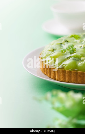 Tarte kiwi et raisin muscat sur la plaque, fond vert Banque D'Images