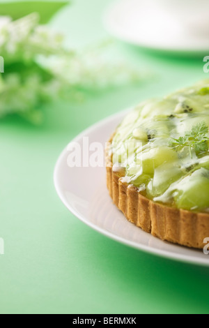 Tarte kiwi et raisin muscat sur la plaque, fond vert Banque D'Images