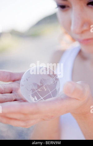 Young woman holding globe dans les mains, Close up Banque D'Images