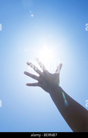 Woman's hand reaching sun Banque D'Images