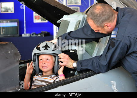 Dans le cockpit de l'enfant portant un casque de pilote de chasse à l'Airshow à Koksijde, Belgique Banque D'Images