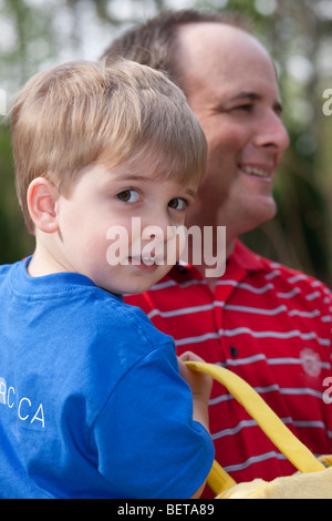 Close-up plaisir expressif 2 à 3 ans Homme de race blanche blonde enfant dans les bras de smiling dad profondeur de champ Banque D'Images