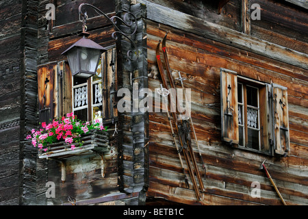 Vieux skis à l'avant de la maison en bois traditionnelle suisse / chalet dans le village alpin de Grimentz, Valais, Suisse Banque D'Images