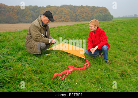 Grand-père et petit-fils flying a kite ensemble Banque D'Images