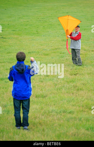 Grand-père et petit-fils flying a kite ensemble Banque D'Images