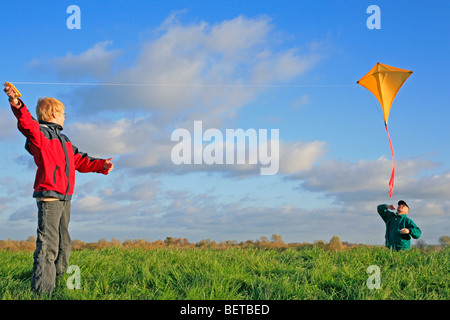 Grand-père et petit-fils flying a kite ensemble Banque D'Images