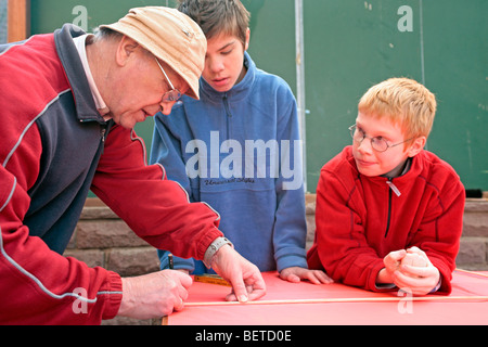 Grand-père et ses petits-fils l'édification d'un ensemble de kite Banque D'Images