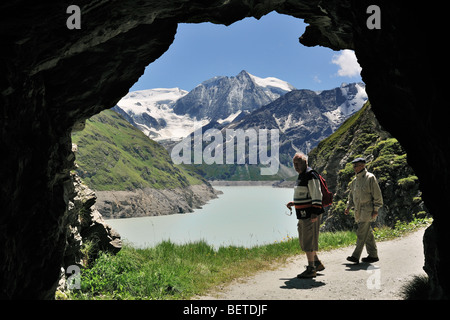 Marche à travers les touristes le long de la grotte Lac des Dix, formé par le barrage de la Grande Dixence, Valais, Alpes Suisses, Suisse Banque D'Images