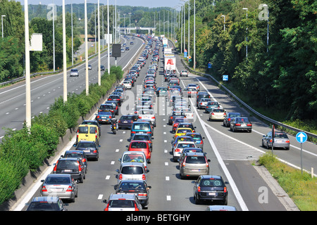 Les voitures et les camions en attente à l'approche des voies d'autoroute bretelle au cours embouteillage sur l'autoroute pendant les vacances, en Belgique Banque D'Images