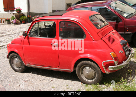 Fiat 500 rouge vif bambino dans un village alpin italien Banque D'Images