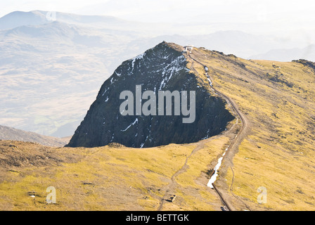 Vue aérienne de la crête menant au sommet de Snowdon (Yr Wyddfa) dans le parc national de Snowdonia, pays de Galles, avec un sentier de montagne et des taches de neige sur le t Banque D'Images