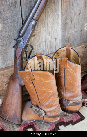 Cowboy & film l'acteur John Wayne's shotgun et bottes en cuir cowoby et eperons utilisé dans plusieurs de ses films de l'ouest. Banque D'Images