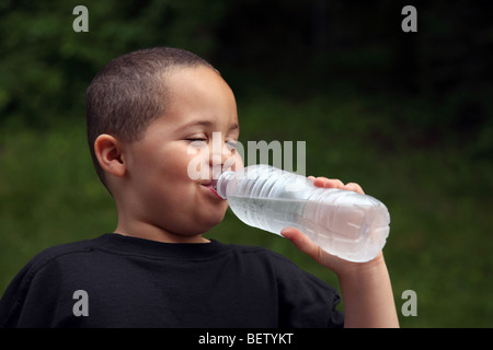 Garçon Latino l'eau potable de la bouteille Banque D'Images