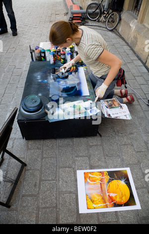 L'artiste local produisant des peintures de science-fiction à vendre aux touristes, à la place du marché / Markt. Cracovie. La Pologne. Banque D'Images
