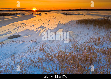 Coucher de soleil sur un lac gelé dans l'aire de gestion de la faune de Churchill, Churchill, Manitoba, la baie d'Hudson, au Canada. Banque D'Images